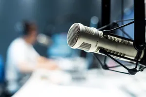 Radiostudio mit Mikrophon im Vordergrund.